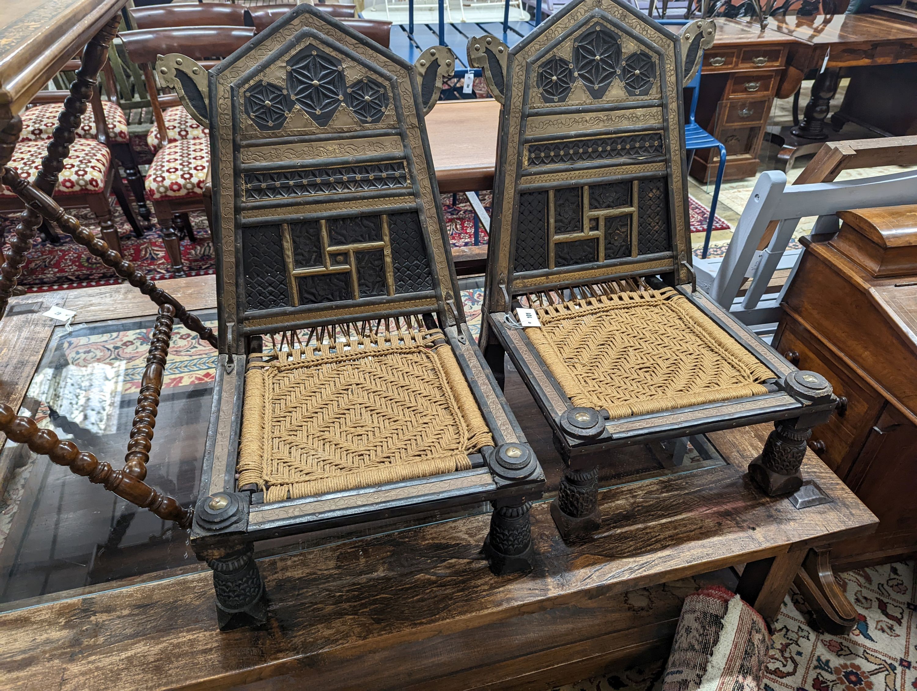 A pair of Afghan chip-carved and brass-mounted low seat chairs with woven seats, width 45cm, depth 45cm, height 76cm